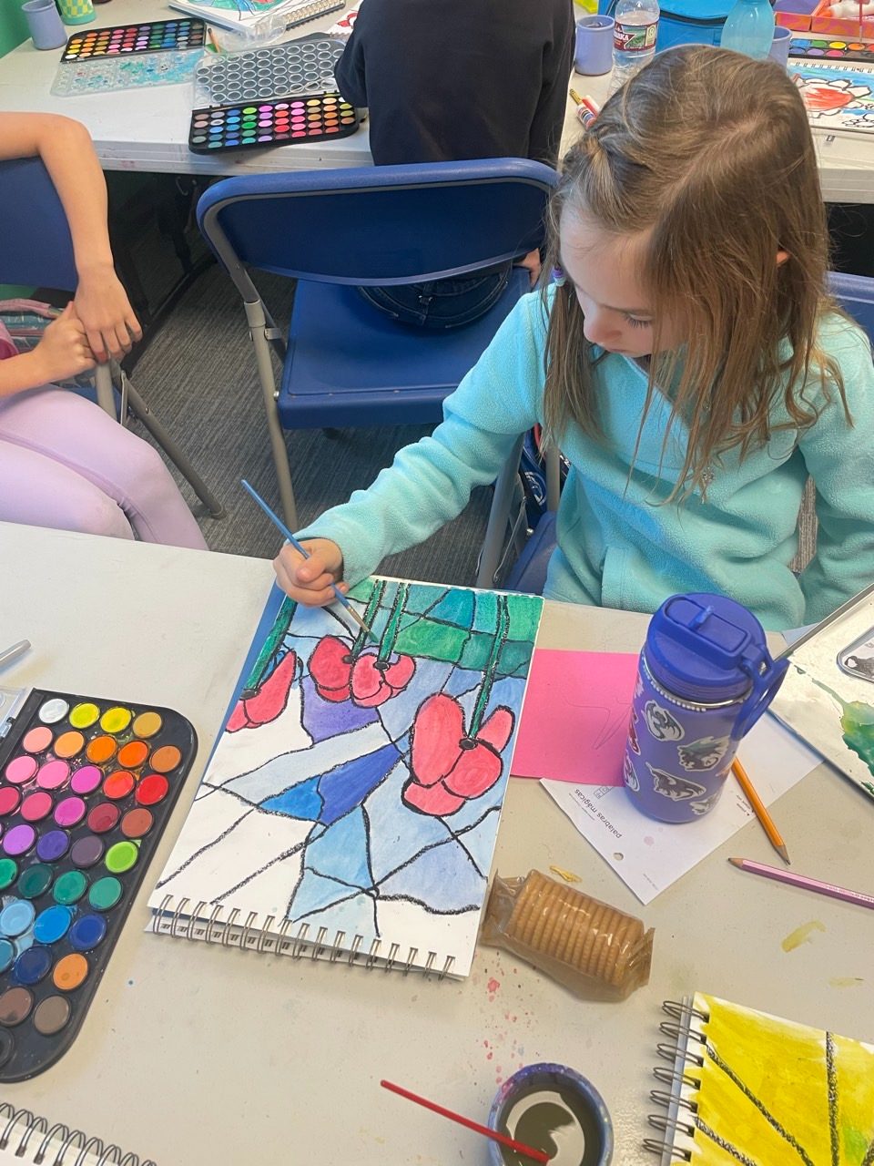 A child painting a stained-glass style watercolor of poppies